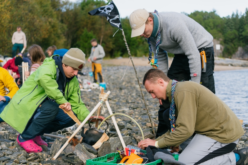 Speidere som jobber med utstyr ved strandkanten