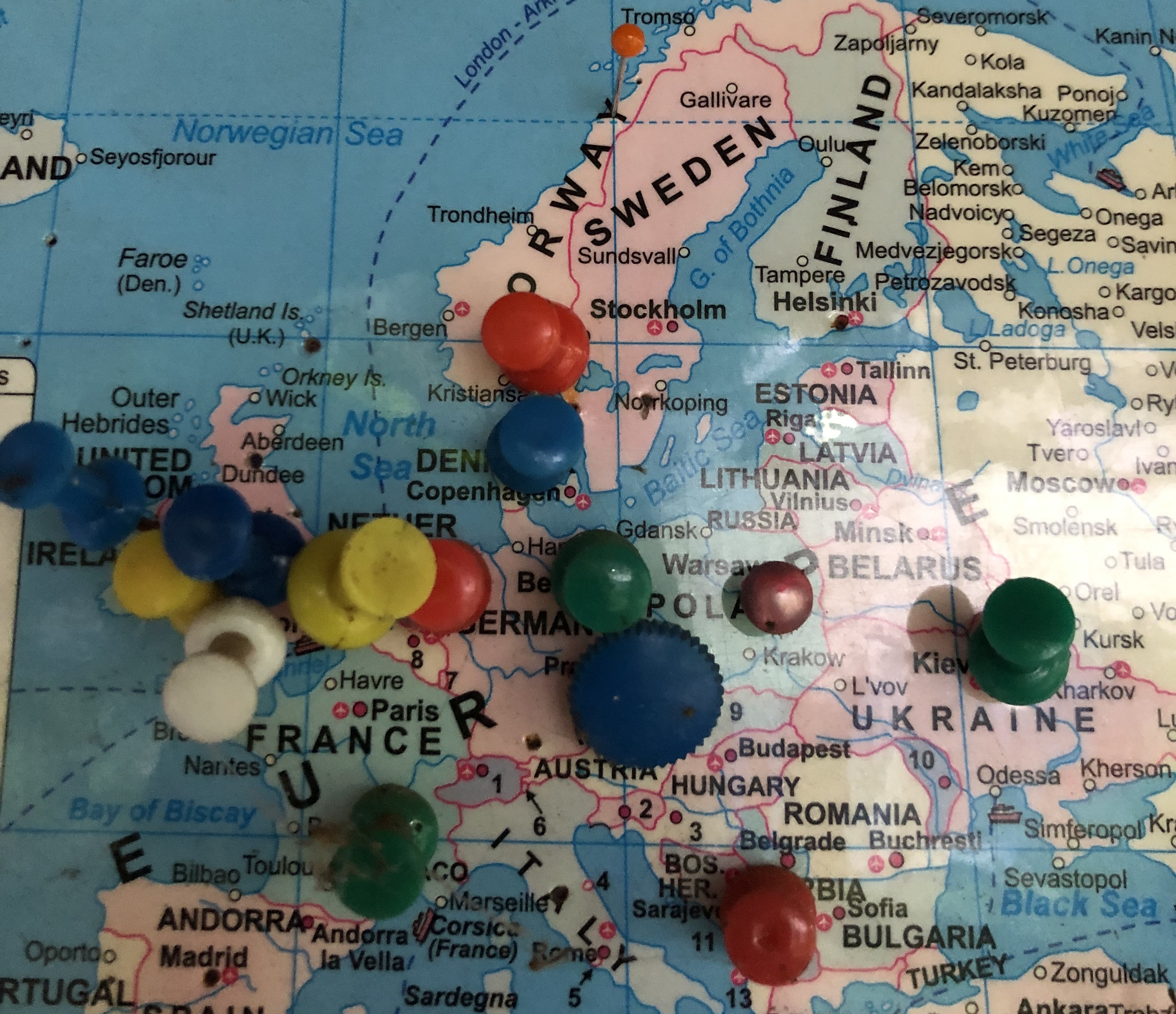 Fargerike knappenåler stukket inn i et europakart