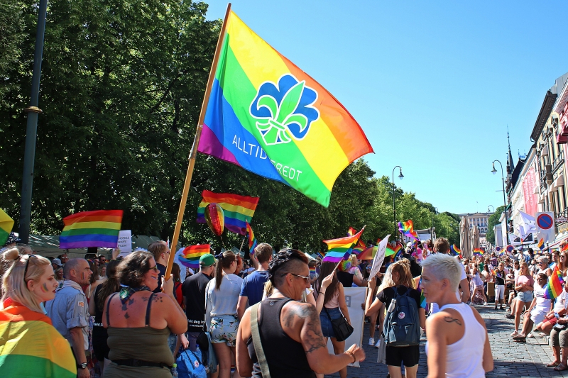 Pridetog på Karl Johan i Oslo. Mange mennekser bærer regnbueflagg.