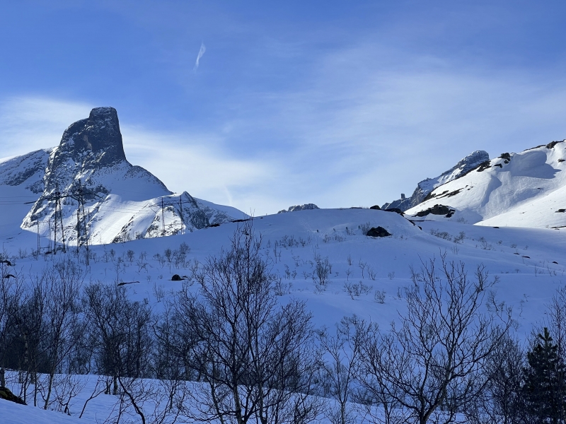 Vinterlandskap i fjellet med snødekte topper og blå himmel