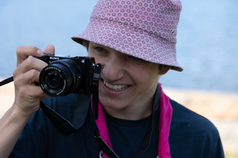 Person med rosa bøttehatt fotograferer med et Sony-kamera