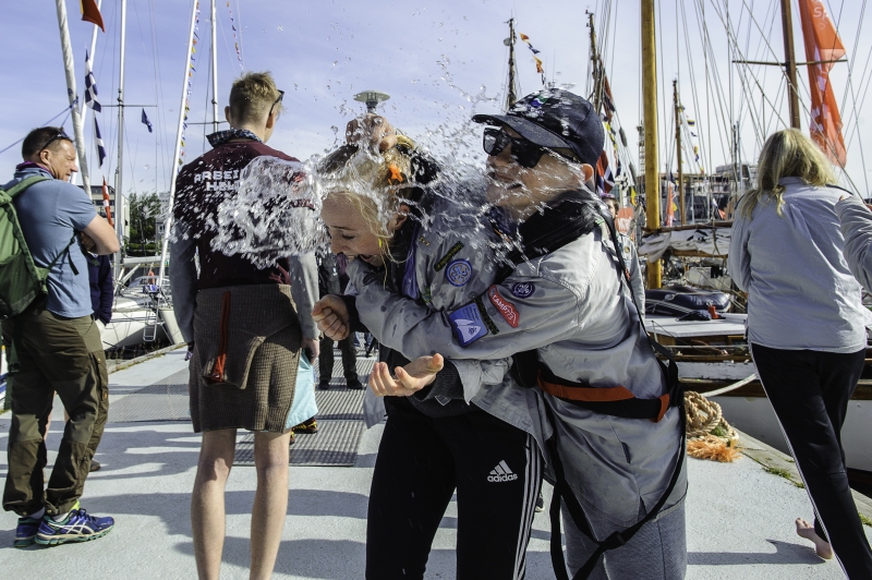 En speidersom kaster vann på en annen speider, de smiler og ler