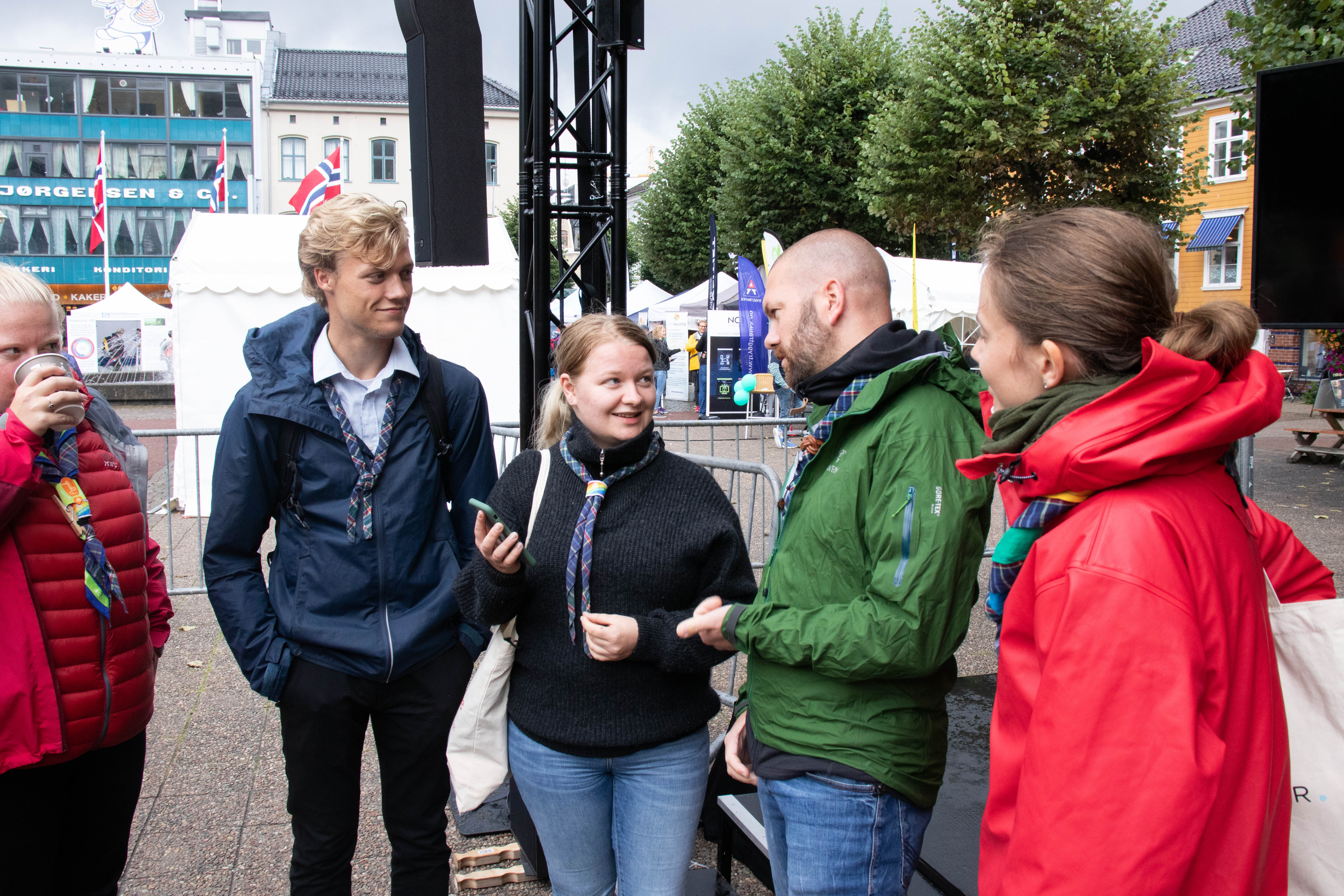 Speidere i samtale på et torg under en aksjon
