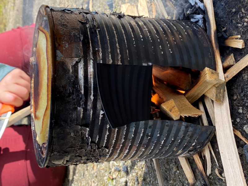 bål inni en blekkboks, hvor det stekes sveler på toppen