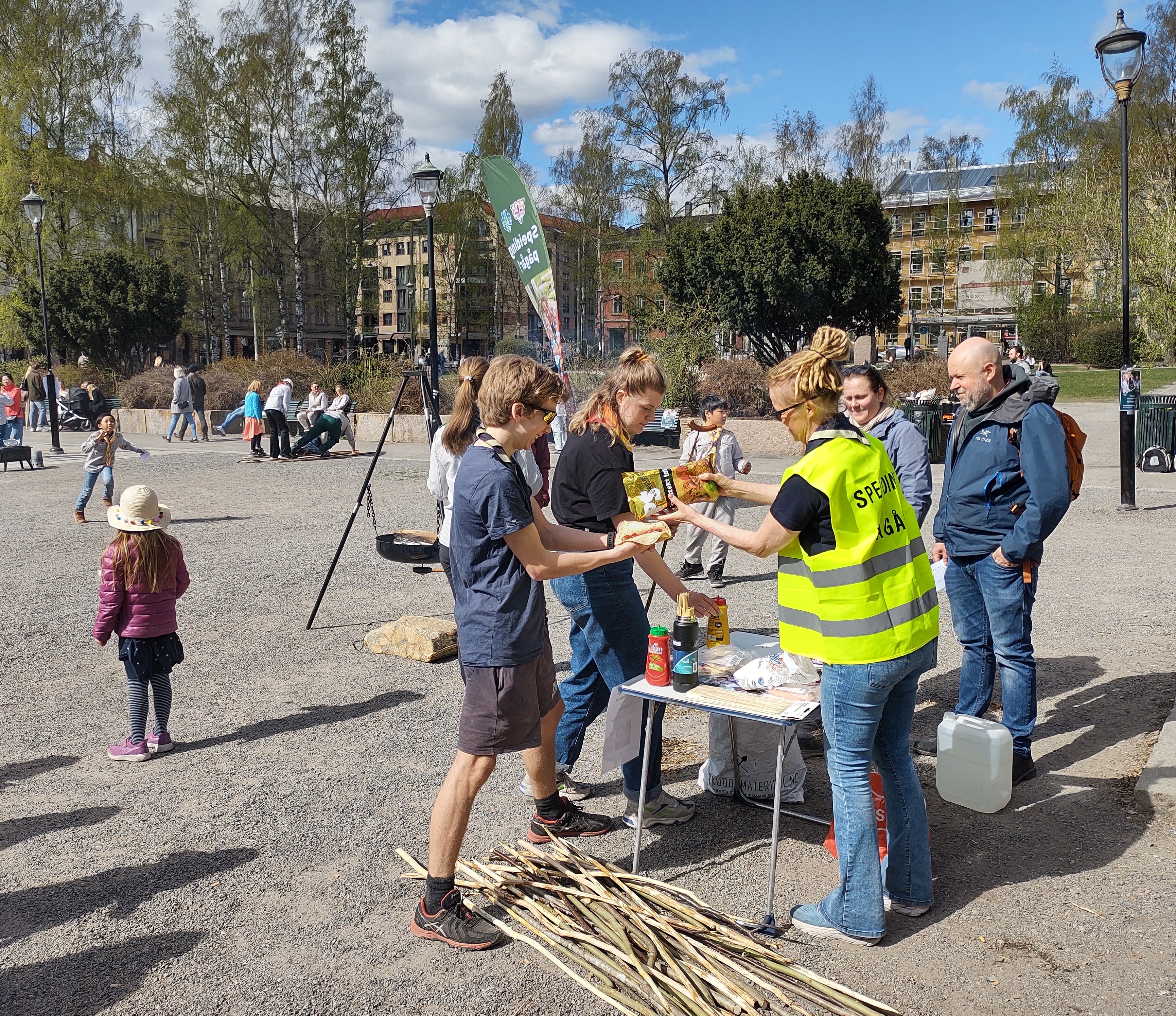 Speidere og ledere deler ut mat og viser frem speideraktiviteter på et torg under Speidingens dag
