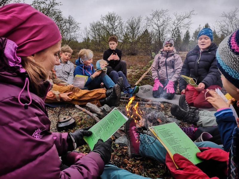 Speidere som sitter rundt bålet og synger
